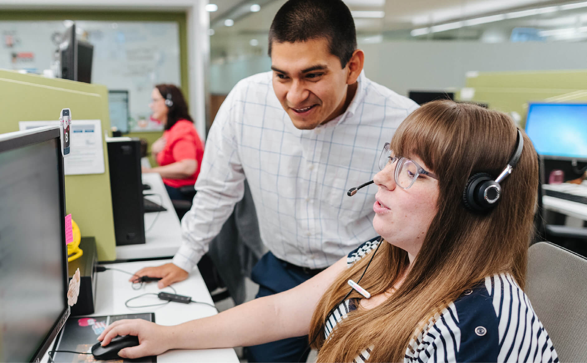 Two Capital One associates collaborate at a desk in front of a computer